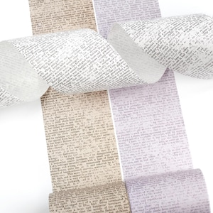 May include: Decorative washi tape rolls with a vintage book page design. The tape features text in shades of white, beige, and lavender. The rolls are unrolled, showing the printed text and the adhesive side.