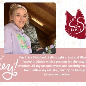 May include: A woman in a purple hoodie with a graphic design on the front is holding a sketchbook. The text on the image reads "I'm Erica Stoddard. Self-taught artist and illustrator based in Maine with a passion for the magic of creation. All my art and prints are carefully made with love. Follow my artistic journey on Instagram @ericastoddardart"