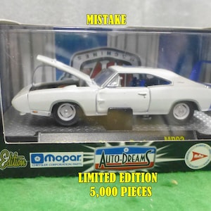 May include: White die-cast model car of a Dodge Charger Daytona with a blue rear wing, hood open, and displayed in a box. The box features the text "Premium Edition", "Mopar", and "Auto-Dreams". The box also states "Limited Edition 5,000 Pieces".