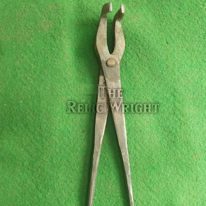 May include: A vintage metal tool with long handles and curved jaws, likely used for gripping or shaping metal. The tool is displayed against a green background, with the text "THE RELIC WRIGHT" visible.