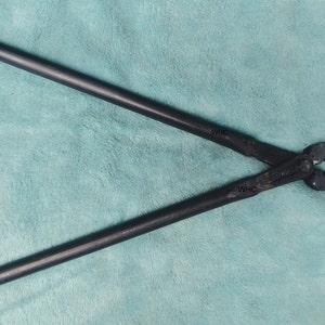 May include: A pair of black metal pliers with the text "WHC" stamped on each handle.