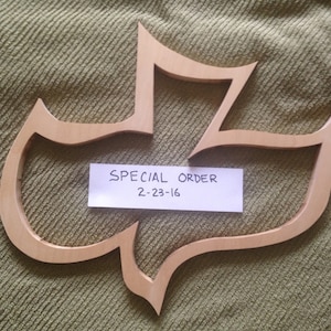 May include: A wooden cutout of a dove, a Christian symbol, with the text "SPECIAL ORDER 2-23-16" written on a white piece of paper.