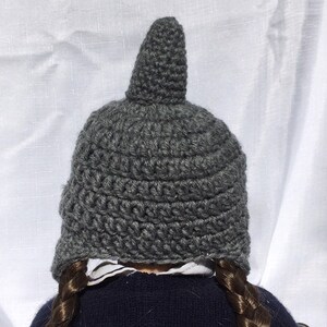 May include: Gray crocheted hat with a pointed top. The hat is made with a simple stitch pattern and has a slouchy fit.