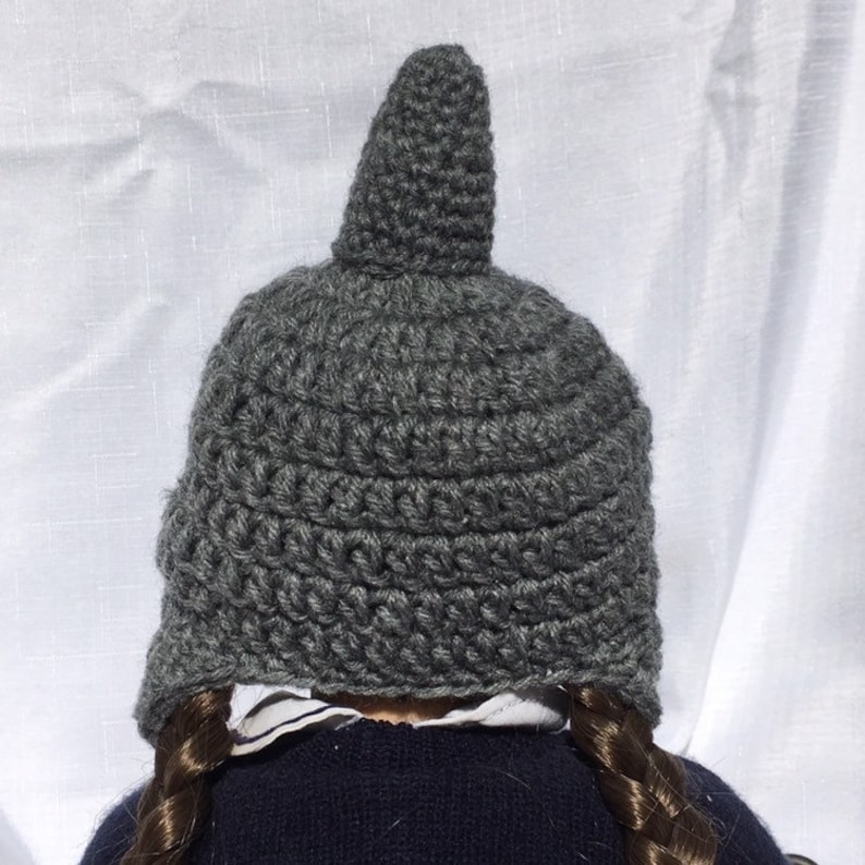 May include: Gray crocheted hat with a pointed top. The hat is made with a simple stitch pattern and has a slouchy fit.