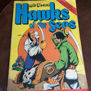 May include: A vintage comic book cover featuring a colorful illustration of pirates with swords and a treasure chest. The title of the comic is "Will Eisner's Hawks of the Seas" with the text "A landmark collection of Will Eisner's first major work: 1936-38" and "With an Introduction by Al Williamson".