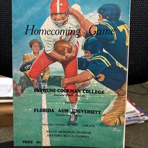 May include: A vintage program for a homecoming football game between Bethune-Cookman College and Florida A&M University. The program features a colorful illustration of two football players in action. The game was held on Saturday, October 22, 1960, at Welch Memorial Stadium in Daytona Beach, Florida. The price of the program was 25 cents.