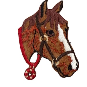 May include: Embroidered iron-on patch of a brown horse head with a red halter. The horse has a white stripe on its face.