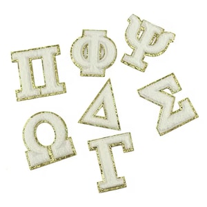 May include: White felt Greek letters and symbols with gold glitter trim. The letters include: Pi, Phi, Psi, Delta, Sigma, Omega, and Gamma.