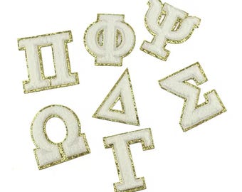 May include: White felt Greek letters and symbols with gold glitter trim. The letters include: Pi, Phi, Psi, Delta, Sigma, Omega, and Gamma.