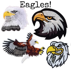May include: Four embroidered patches featuring eagle designs with the text "Eagles!" at the top. The patches include three detailed eagle head portraits in white, black, and yellow, and one full-body eagle in flight with brown, white, and black feathers.