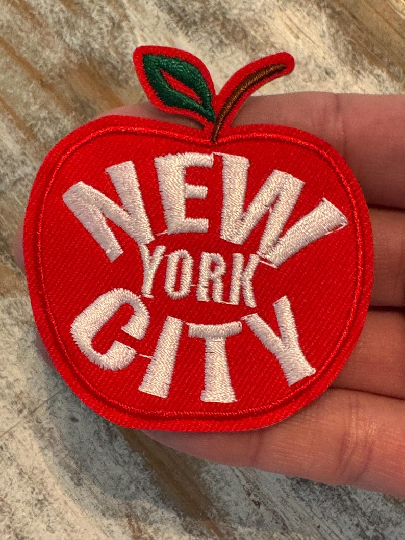 Pu&ograve; includere: Toppa a forma di mela rossa con testo ricamato bianco che recita "NEW YORK CITY".