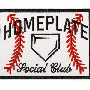May include: A rectangular patch with a white background, black border, and the words "HOMEPLATE Social Club" in black script. Red baseball stitching and a home plate graphic are also featured.