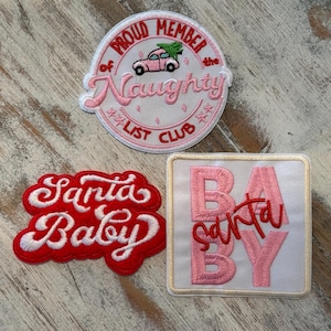 May include: Three embroidered patches with Christmas themes. One patch is round and pink with the text "Proud Member of the Naughty List Club". Another patch is red with the words "Santa Baby". The third patch is square and white with the words "Santa Baby".