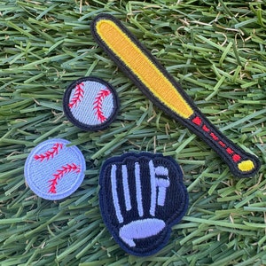May include: A set of four embroidered iron-on patches featuring baseball equipment. The patches include a baseball bat, a baseball, a baseball glove, and a baseball with red stitching.