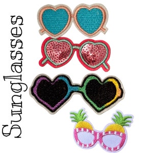 May include: Four different styles of iron-on patches featuring sunglasses. The sunglasses are in the shapes of hearts, with different colors and patterns. The patches are perfect for adding a fun and stylish touch to clothing, bags, or other accessories.