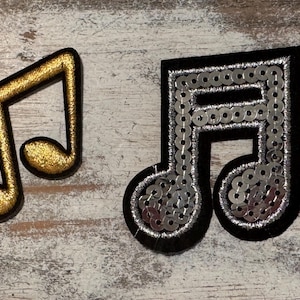 May include: Two musical note patches, one gold and one black with silver sequins.