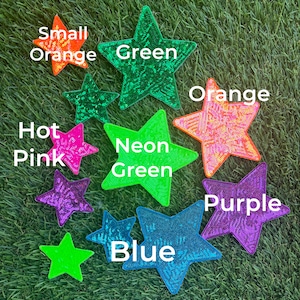 May include: Assortment of colorful sequin star iron-on patches in various sizes.  The colors include hot pink, neon green, blue, purple, orange, and green.