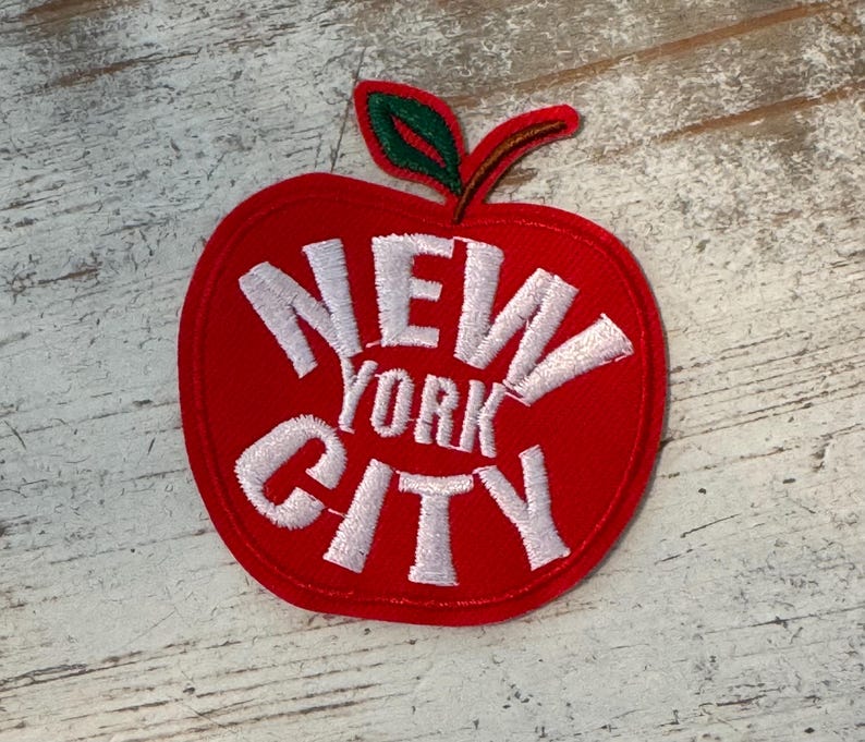 Pu&ograve; includere: Toppa a forma di mela rossa con testo ricamato bianco che recita "NEW YORK CITY".
