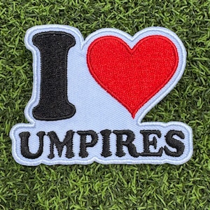 May include: White embroidered patch with a black "I" and a red heart, with the text "UMPINES" below.