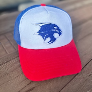 May include: A white and blue trucker hat with a red brim. The hat features a blue and white embroidered panther logo.