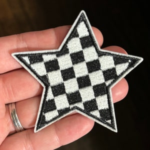 May include: A black and white checkered star-shaped iron-on patch.