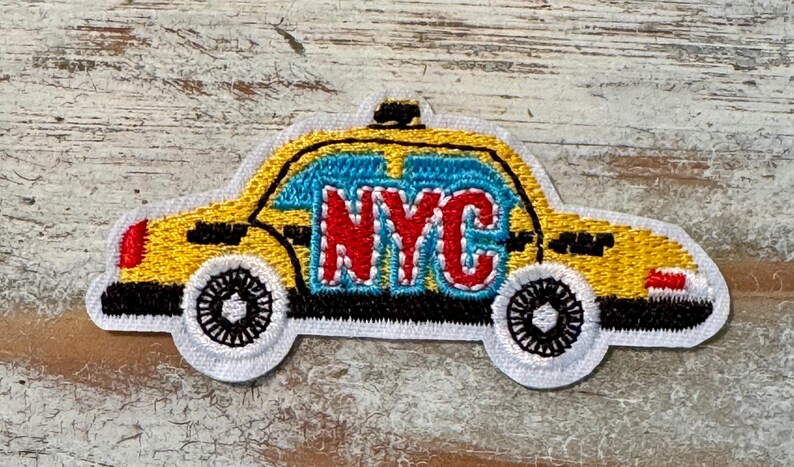 Pu&ograve; includere: Toppa ricamata gialla di un taxi di New York City con la parola "NYC" in lettere rosse sul lato.
