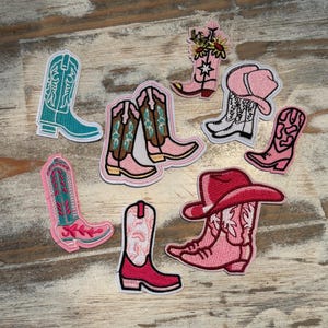 May include: A collection of nine embroidered iron-on patches featuring cowboy boots in various colors and designs. The patches are perfect for adding a touch of Western flair to clothing, bags, or other accessories.