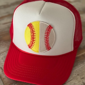 May include: A red and white trucker hat with a yellow and white baseball embroidered on the front.