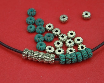 May include: A close-up of a leather cord with silver and turquoise beads. The beads are arranged in a pattern and are interspersed with silver spacer beads.