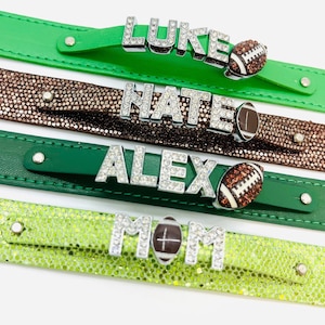 May include: Four green and brown leather bracelets with rhinestones spelling out the names "LUKE", "NATE", "ALEX", and "MOM" with a football charm on each.