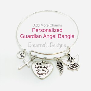Peut inclure: Bracelet en argent avec un charme en forme de c&oelig;ur qui dit "You are always in my heart!" et d'autres charmes, dont une croix, une aile et un ange avec le texte "Angels Watching Over Me".