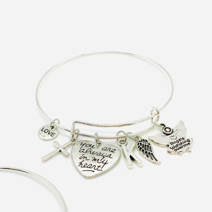 Peut inclure: Bracelet en argent avec un charme en forme de c&oelig;ur qui dit "You are always in my heart", un charme en forme de croix, un charme en forme de lettre K, un charme en forme d'aile d'ange et un charme en forme d'ange qui dit "Angels watching over me".