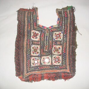 May include: A colorful embroidered fabric panel with a geometric design and small round mirrors. The panel is brown with red, green, blue, and white embroidery.