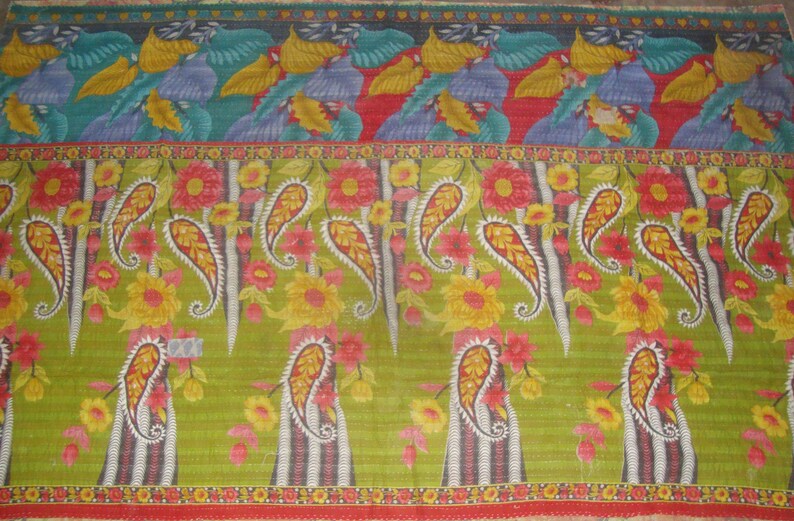 May include: A colorful textile with a repeating pattern of paisley and floral designs. The top section features stylized bird and leaf motifs in shades of blue, yellow, and green. The central section showcases large paisley shapes with red and yellow flowers.