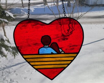 Stained glass Sweethearts, this a couple inside a heart. Sitting on a bench.