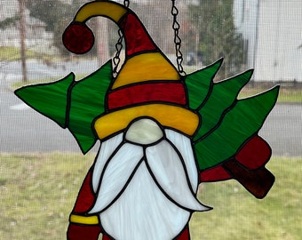 Stained glass Christmas Gnome carrying a Christmas tree.