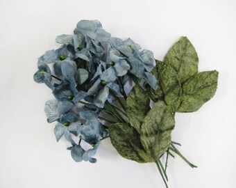 以下が含まれることがあります： 青いベルベットの花と緑のベルベットの葉のブーケ