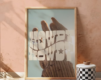 May include: A framed print with a light blue background featuring a close-up of a saguaro cactus with the text "Howdy Howdy" in white.