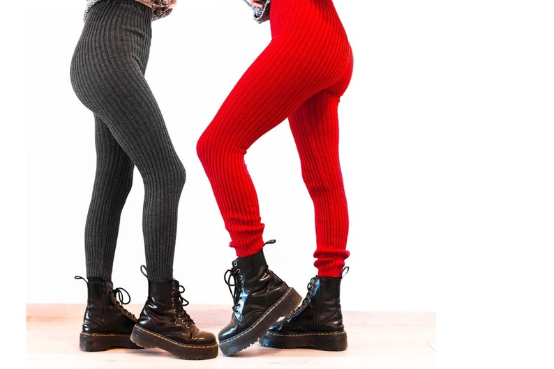 Two people wearing red and dark grey ribbed knitted leggings standing opposite each other.