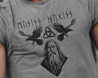 May include: A gray t-shirt with a black and white graphic print of a bearded man with two ravens and the text "MÐNIXX NÐXIXX".