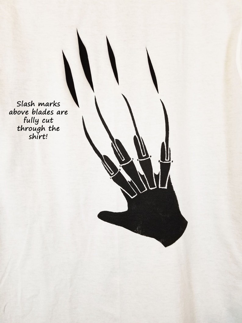 May include: White t-shirt with a black graphic of a hand with claws. The text "Slash marks above blades are fully cut through the shirt!" is printed on the shirt.