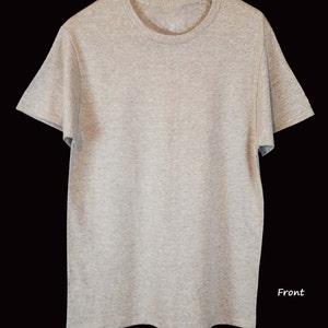 May include: A heather gray short-sleeved t-shirt with a crew neck. The shirt is made of a soft, textured fabric and is displayed against a black background. The word "Front" is written in white script on the lower right side of the shirt.