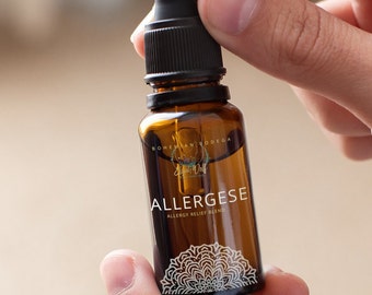 May include: A brown glass bottle with a black dropper top. The bottle is labeled "ALLERGESE" and "ALLERGY RELIEF BLEND".