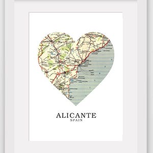 May include: A vintage map of Alicante, Spain, in the shape of a heart. The map shows roads, towns, and the coastline.