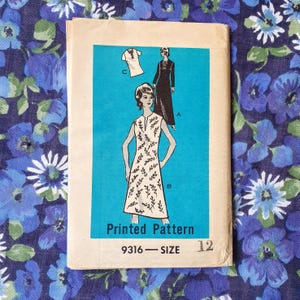 May include: A vintage dressmaking pattern with illustrations of three dress designs. The pattern is labelled "Printed Pattern" with the number "9316" and size "12". The background is a vibrant blue with floral patterns.
