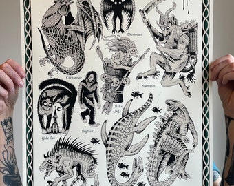 May include: Black and white illustration of various mythical creatures, including a Cockatrice, Mothman, Krampus, Baba Yaga, Bigfoot, Nessie, Godzilla, Chupacabra, and a Hide Cat. The illustration is on a cream-colored background with a green border.