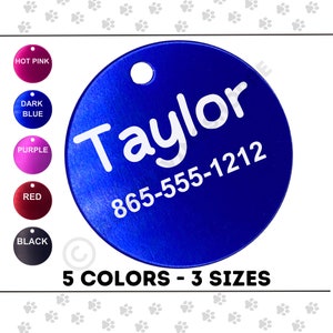 May include: A blue, circular pet tag with the name "Taylor" and a phone number in white. The tag has a hole for attachment and is shown with color options: hot pink, dark blue, purple, red, and black. Text at the bottom reads "5 COLORS - 3 SIZES."