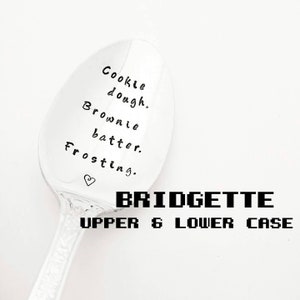 May include: A silver spoon with the words "Cookie dough. Brownie batter. Frosting." and a heart symbol. The name "BRIDGETTE" and "UPPER & LOWER CASE" are printed below the spoon.