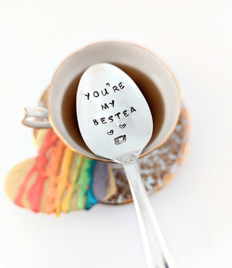 vintage silver plated spoon with the words ' you're my bestea' engraved on them. There is also a design or a tea cup and hearts.