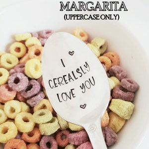 May include: A white ceramic bowl filled with colorful cereal, with a silver spoon that reads "I Cerealsly Love You." The word "Margarita" is above the bowl in uppercase letters.
